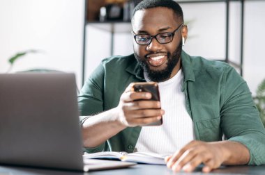 İnternette sohbet ediyoruz. Neşeli bir Afrikalı Amerikalı, masasında oturuyor, çalışırken cep telefonu kullanıyor, internette geziniyor, e-postalara cevap veriyor, arkadaş ya da aileyle sohbet ediyor.