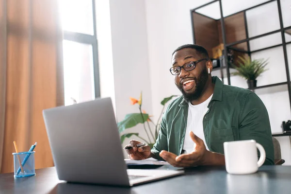 Distance learning at home, online working. African American guy student or freelancer uses a laptop for learning or working, having video conference
