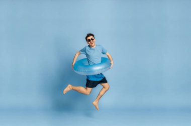 Adam mavi arka plan tatil plajı şişirilebilir yüzük yazını izole etti.