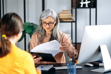 Güzel gri saçlı Asyalı kadın gözlük takıyor, İK müdürü, aday, ofis, özgeçmiş, gülümsüyor.