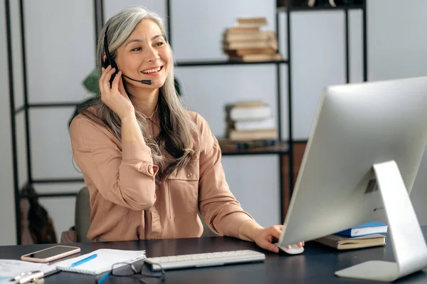 Asian business woman, call center, office, online conference, headset, smiling