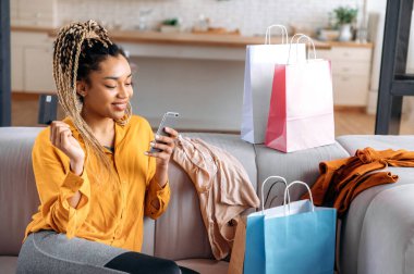 Afrikalı Amerikalı güzel bir kadın online kredi kartı alışverişi yapıyor.