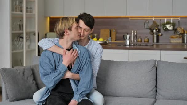 Homosexuelle Jungs. Liebendes schwules Paar, zu Hause sitzen, sich zärtlich umarmen und streicheln, gemeinsam auf dem Sofa im Wohnzimmer entspannen, Zeit miteinander verbringen, gleichgeschlechtliches Paar — Stockvideo