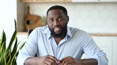 İç görüşme. Arkadaş canlısı, kendinden emin, genç, Afro-Amerikan sakallı adam, CEO, serbest çalışan ya da danışman, video konferansı sırasında iş arkadaşları ya da müşterilerle konuşuyor, elleriyle hareket ediyor, gülümsüyor.