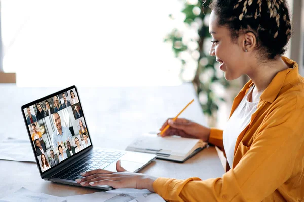 Belső eligazítás, konferencia. Afrikai amerikai női menedzser kommunikál az üzleti csapattal videohívás közben, pénzügyi webináriumot hallgat, jegyzetel, laptop képernyőbarát multiracionális embereken — Stock Fotó