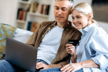 Odaklanamayan mutlu beyaz çift aşık, mutlu karı koca, dizüstü bilgisayar ve kredi kartını kullanarak mal, giysi veya teslimat, online alışveriş, e-ticaret konsepti