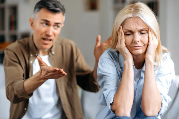 Married mature couple emotionally discuss about problem. Middle aged husband and wife disagree with each other, have a misunderstanding, cant make decision or compromise, a quarrel between spouses