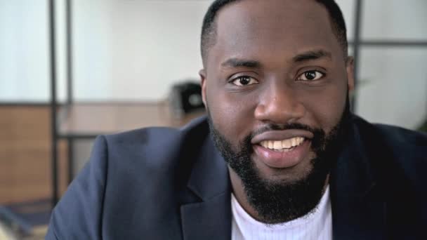 Close-up vídeo retrato de um atraente confiante bem sucedido homem barbudo americano africano inteligente, empresário ou advogado, vestindo um terno formal elegante, amigável olhando para a câmera, sorrindo — Vídeo de Stock
