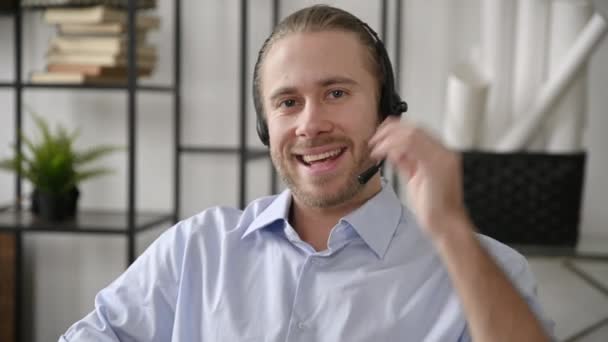 Carismático amigable americano satisfecho hombre, operador de call center, líder empresarial, experto, tutor en auriculares y camisa formal hablando por videoconferencia con colega, lleva a cabo la consulta en línea — Vídeo de stock