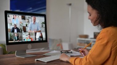Uzaktan öğrenme, online ders. Afrikalı Amerikalı zeki kız, öğrenci ya da serbest çalışan, video konferansını dinleyen ve izleyen, notlar alan, bilgi toplayan, ekranda çok ırklı insanlar.