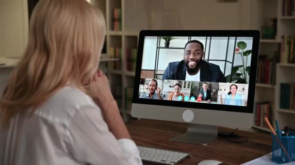 Reunión de negocios en línea. Ver sobre un hombro de las mujeres en una pantalla de ordenador con personas multirraciales, equipo de negocios se reunieron en conferencia en línea de diferentes partes del mundo para discutir temas de trabajo — Vídeo de stock