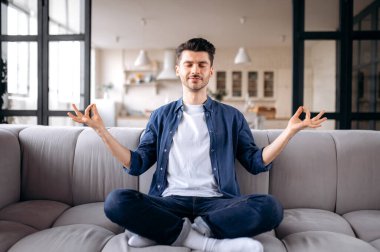 Rahat, çekici, beyaz bir adam. Rahat, sakin bir adam. Oturma odasındaki kanepede oturur, gözleri kapalı meditasyon yapar.