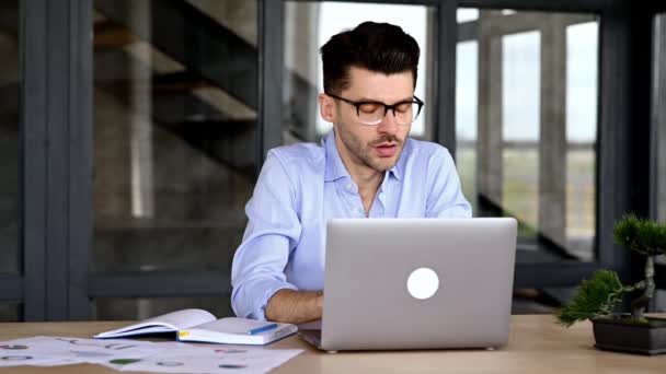 Frustrado agotado caucásico joven adulto, gerente, freelancer o empleado de la oficina, se siente cansado de muchas tareas de trabajo, en el estrés, se tomó un descanso, se quita las gafas, necesita descanso, tiene dolor de cabeza, migraña — Vídeo de stock