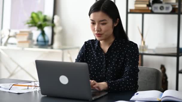 Emocionado emocionado asiático, chica japonesa, freelancer, gerente, trabajando con el ordenador portátil, mira a la pantalla con sorpresa, cara sonriente, gesto con las manos, consiguió un trabajo de ensueño, gran beneficio, ganar, buenas noticias — Vídeo de stock