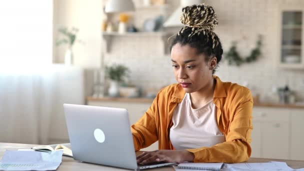 Traurig frustrierte Afroamerikanerin, Studentin, Managerin oder Freiberuflerin, die zu Hause mit Laptop arbeitet oder studiert, bei der Arbeit gestresst, überarbeitet, bei einem Deal gescheitert, den Kopf mit den Händen gehalten — Stockvideo