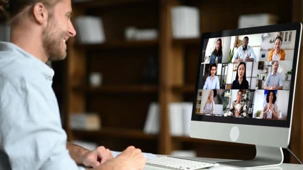 Brainstorm do grupo, briefing de negócios online. Homem caucasiano bem sucedido usa computador para uma chamada de vídeo, reunião virtual com parceiros, senta-se no local de trabalho, pessoas multirraciais diversas na tela do computador — Vídeo de Stock