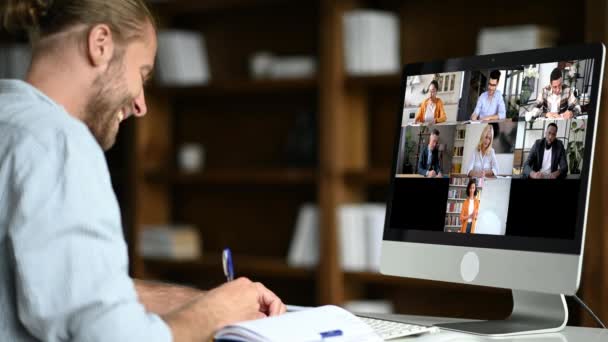 Educación en línea, e-learning. Caucásico chico seguro inteligente sentado en un escritorio, utiliza la computadora, escuchando una conferencia en línea, tomando notas, un profesor y diversas personas en la pantalla — Vídeos de Stock