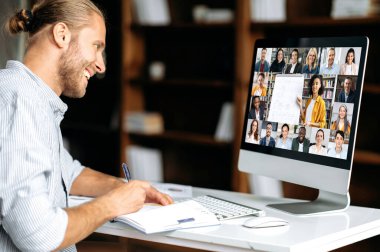 Online eğitim. Zeki beyaz adam internette izleme dersi alarak bilgi kazanıyor. Genç adam Webinar sırasında not alıyor, video konuşması üzerine konferans veriyor. Kadın öğretmen ve öğrenciler ekranda