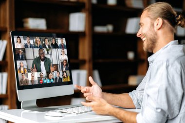 Farklı milletlerden meslektaşlarıyla video konferansında konuşan başarılı bir beyaz adam, proje ve stratejiyi tartışıyor. Çevrimiçi iş toplantısı, çalışanların beyin fırtınası.