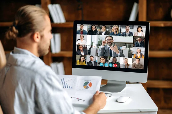 Online business meeting, brainstorm of employees. Successful young man talking on video conference with colleagues of different nationalities, discussing the project, analysis financial graph — Stock Photo, Image