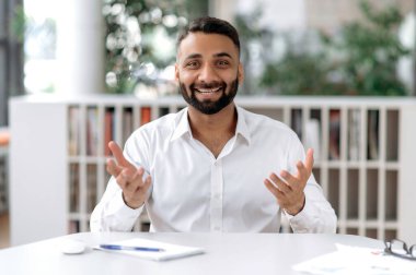 Arkadaş canlısı, kendine güvenen Hintli iş adamı ya da akıl hocası, konferans görüşmesinde iş arkadaşı ya da müşteriyle iletişim kuran, kameraya bakan, el kol hareketi yapan, hoş gülümseyen, online röportaj yapan