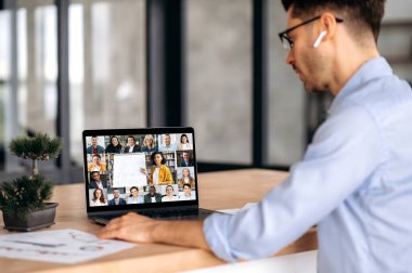 E-öğrenme konsepti. Kafkasyalı modern bir adam, uzaktan çalışıyor, çevrimiçi bir ders dinliyor, bayan öğretmen bir ders veriyor, farklı yaşlardan çok uluslu öğrenciler bilgi kazanıyor.
