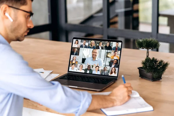 Kaukázusi férfi végrehajtó, amelynek online virtuális találkozó keresztül videokonferencia sikeres multiracionális kollégák, laptoppal, ül az irodában, tervezés marketing stratégia és ötletek — Stock Fotó