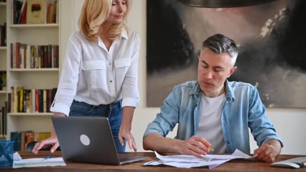 Vergadering van zakenpartners. Twee zelfverzekerde volwassen Kaukasische zakencollega 's die samen aan tafel werken in modern kantoor, zakelijke ideeën bespreken, documenten doornemen, strategie ontwikkelen — Stockvideo