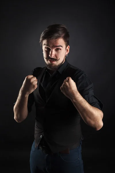 Handsome brutal guy with beard on dark background — Stock Photo, Image