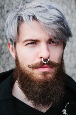 Bearded hipster with nose ring in leather jacket