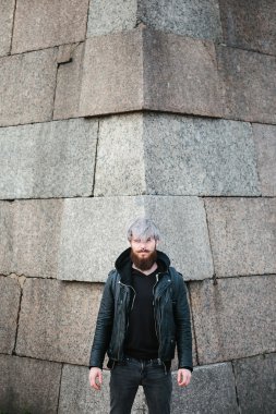 Bearded hipster with nose ring in leather jacket