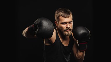 Atletik sakallı boksör eldivenleri karanlık bir arka plan ile
