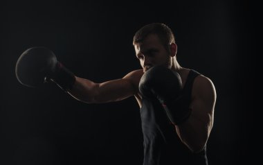 Atletik sakallı boksör eldivenleri karanlık bir arka plan ile