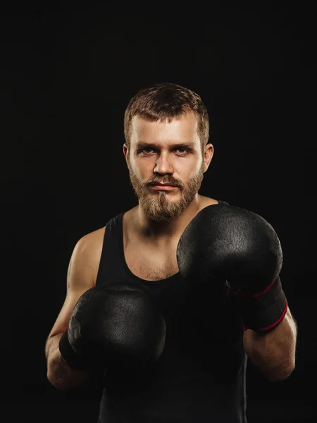 Boxeador atlético barbudo con guantes sobre fondo oscuro —  Fotos de Stock