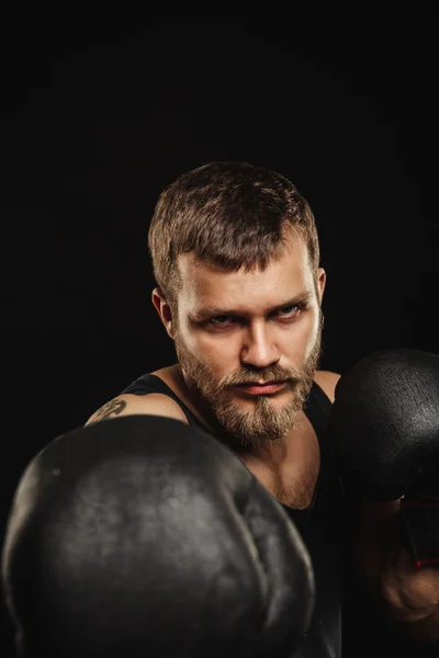 Boxeador atlético barbudo con guantes sobre fondo oscuro — Foto de Stock