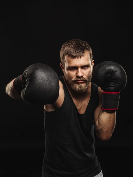 Boxeador atlético barbudo con guantes sobre fondo oscuro —  Fotos de Stock