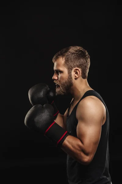 Sportovní vousatý boxer s rukavicemi na tmavém pozadí — Stock fotografie