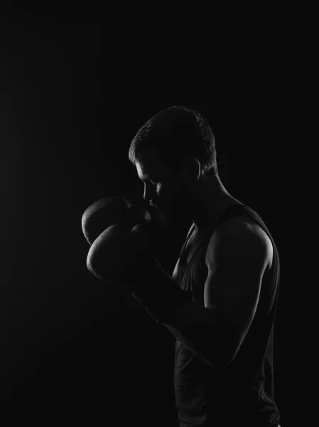 Boxer barbudo atlético com luvas em um fundo escuro — Fotografia de Stock