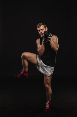 Atletik sakallı boksör eldivenleri karanlık bir arka plan ile