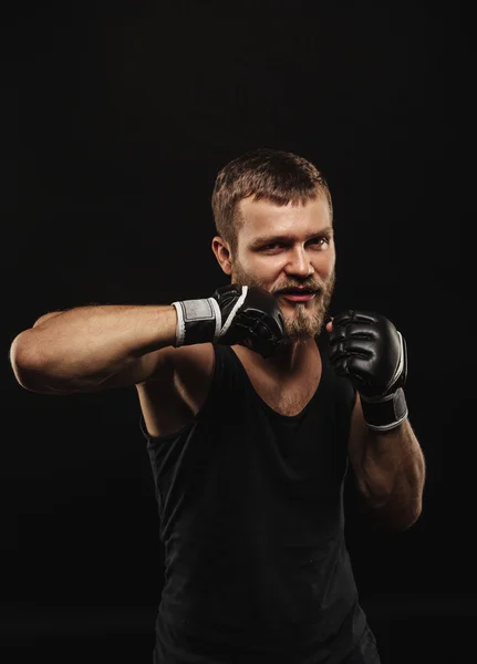 Boxer barbu athlétique avec gants sur fond sombre — Photo