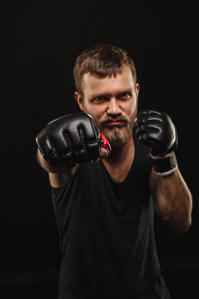 Boxeador atlético barbudo con guantes sobre fondo oscuro — Foto de Stock