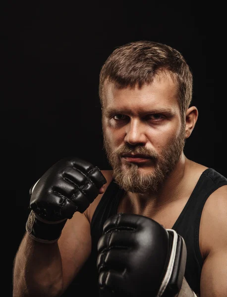 Boxeador atlético barbudo con guantes sobre fondo oscuro —  Fotos de Stock