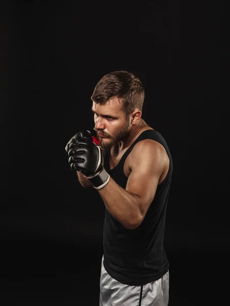 Boxeador atlético barbudo con guantes sobre fondo oscuro — Foto de Stock