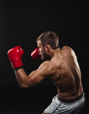 Atletik sakallı boksör eldivenleri karanlık bir arka plan ile