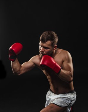 Atletik sakallı boksör eldivenleri karanlık bir arka plan ile