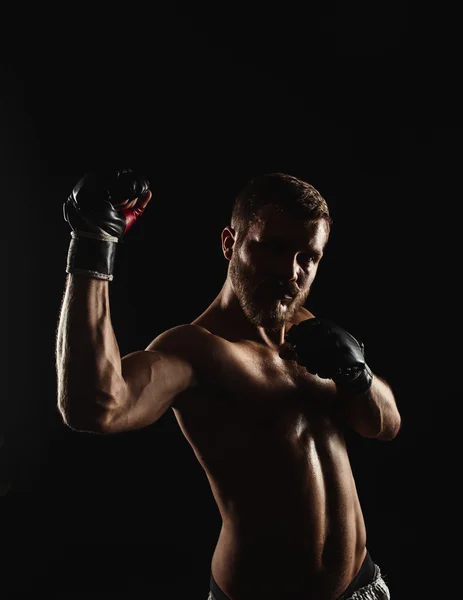 Boxeador atlético barbudo con guantes sobre fondo oscuro — Foto de Stock