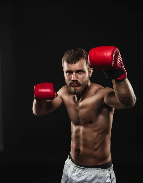 Boxer barbu athlétique avec gants sur fond sombre — Photo