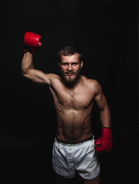 Boxer barbu athlétique avec gants sur fond sombre — Photo