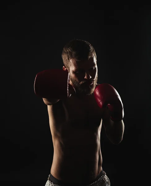 Boxeador atlético barbudo con guantes sobre fondo oscuro —  Fotos de Stock