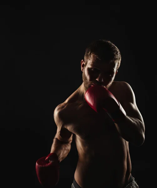 Athletischer bärtiger Boxer mit Handschuhen auf dunklem Hintergrund — Stockfoto